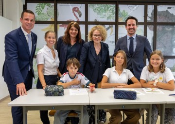 Beim Besuch der Sommerschule in Mödling (v.l.n.r.): Bildungsdirektor Karl Fritthum, Sommerschul-Leiterin Lisbeth Lintner, Direktorin Birgit Gruber-Pernitsch, Landesrätin Christiane Teschl-Hofmeister und Bundesminister Christoph Wiederkehr mit Sommerschul-Kindern Nayel, Amra und Carina (vorne von links).
